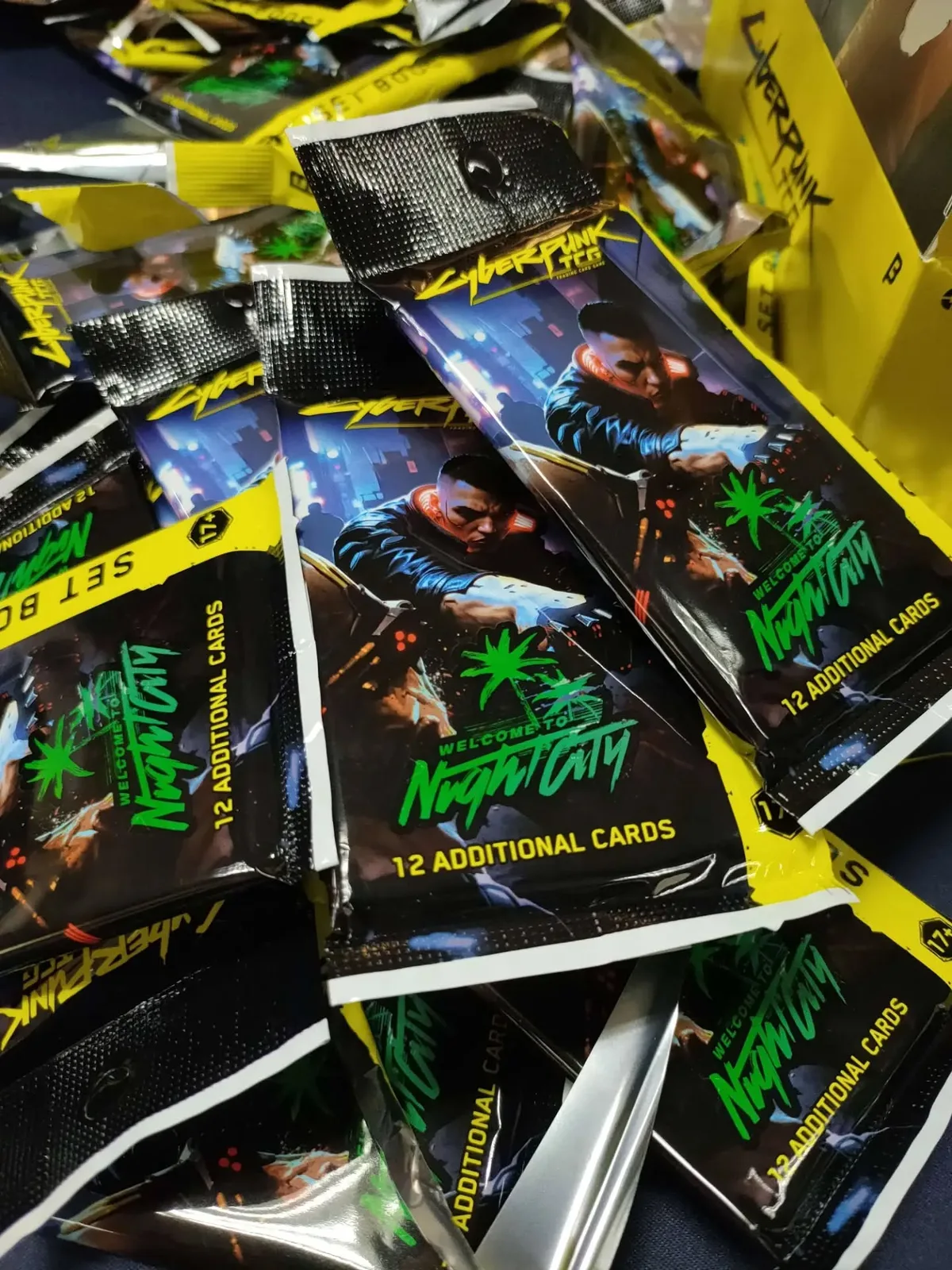 Opened Cyberpunk TCG booster packs and foil wrappers on the table